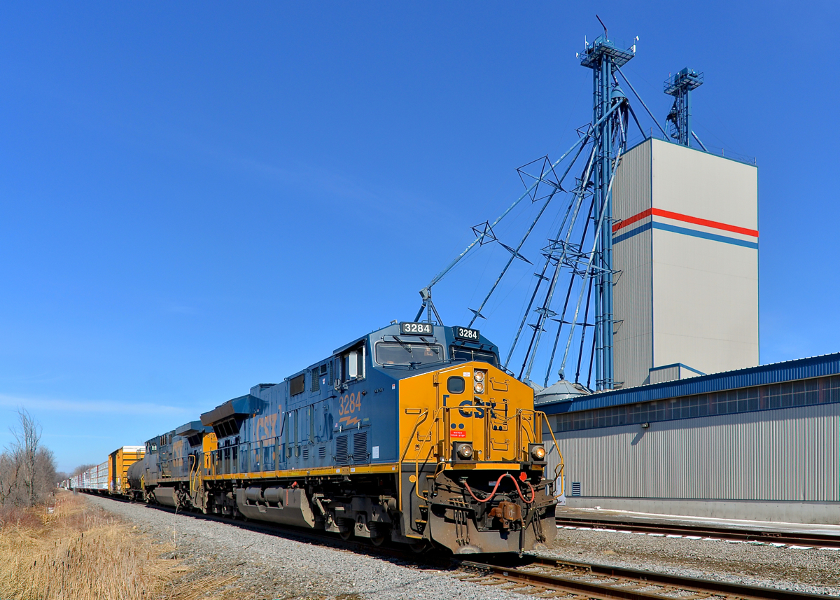 Past the mill. CN 327 has new ET44AH CSXT 3284 leading and CSXT 5101 trailing as it passes a mill in Huntingdon, which is still served by rail.