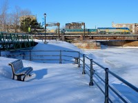 <b>A little too cold for sitting out on a bench.</b> VIA 906 leads VIA 30 from Fallowfield over the frozen Lachine Canal and Peel Basin on a cold morning. At this time of year, I don't think the bench in the foreground sees much use!