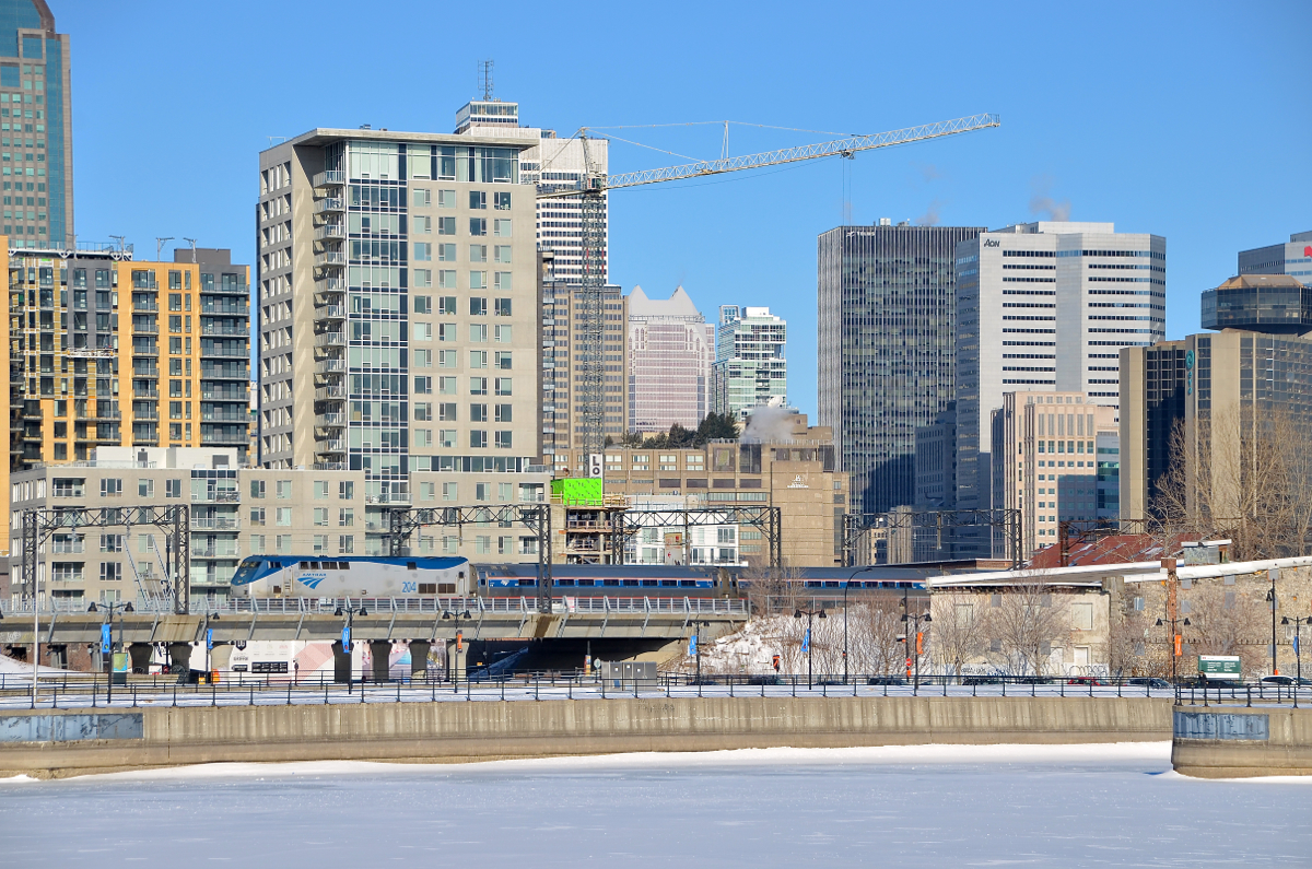 Disappearing into downtown Montreal. The deadheading Adirondack seems to be disappearing into the skyline of downtown Montreal as it deadheads towards Montreal's Central Station on a bright but cold morning.
