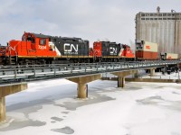 <b>Double GP9's and double stacks into the Port of Montreal.</b> A CN transfer enters the Port of Montreal with a pair of GP9's (CN 7204 & CN 7246, both very clean and in the current CN paint scheme) with a long string of well cars, with double stacks, single stacks and some empties. The train is crossing over the eastern end of the Lachine canal and passing the eastern edge of grain elevator #5.