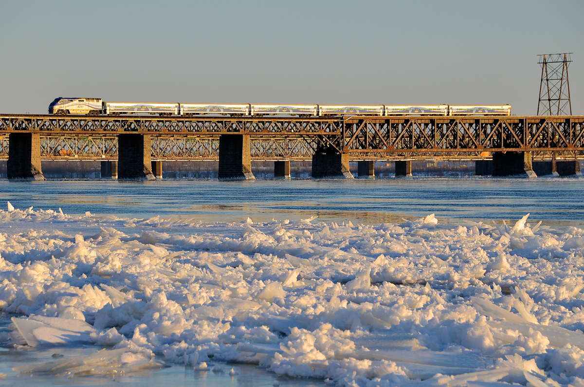 Ice along the river's edge. AMT 1325 leads a deadhead movement from Candiac over the St-Lawrence river during the evening rush hour, on its way back to downtown Montreal. The river still has quite a bit of ice along the shore on the Montreal side of the river.