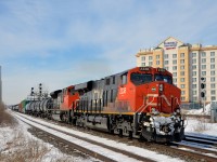 <b>A smiling locomotive!</b> CN 2338 has had a smile etched in the road grime on its front end as it leads CN 368 through Dorval. Trailing is CN 8913, with CN 2333 operating mid-train.