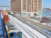 <b>Idling by the old cold storage warehouse.</b> RP20BD POM 1002 is idling with a cut of cars in the Port of Montreal. In the background is right is what once a cold storage warehouse but is now a condominium building.