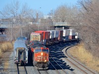 <b>Wating for VIA 633 to pass.</b> CN 120 is stopped on the north track in Montreal West. Now that VIA 633 is passing at left, he can continue and crossover to the south track that VIA 633 was occupying. CN 120 has CN 2548, IC 2707 & CN 2242 as power. This shot is no longer possible as the tunnel I stood on to take this shot will be destroyed any day now.