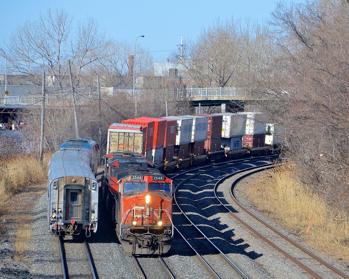 Wating for VIA 633 to pass. CN 120 is stopped on the north track in Montreal West. Now that VIA 633 is passing at left, he can continue and crossover to the south track that VIA 633 was occupying. CN 120 has CN 2548, IC 2707 & CN 2242 as power. This shot is no longer possible as the tunnel I stood on to take this shot will be destroyed any day now.