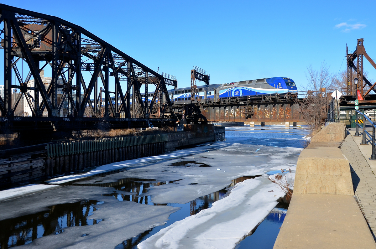 Not much ice left. There's not much ice left in the Lachine canal as AMT 1365 leads the 1650 departure for Mont-Saint-Hilaire (AMT 814) over it.