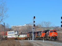 <b>CN 120 around the curve.</b>CN 120 is rounding a curve in the St-Henri neighbourhood of Montreal with a trio of GE's up front, organized newest to oldest. Leading is ET44AC CN 3033 (built in 2015), followed by Dash9-44CW CN 2626 (built in 2000) and CN 2137 (built in 1992 as ATSF 804). ES44AC CN 2809 (built in 2013) is also operating mid-train on this very long 636-axle intermodal train. The head end is passing a relatively new set of signals.
