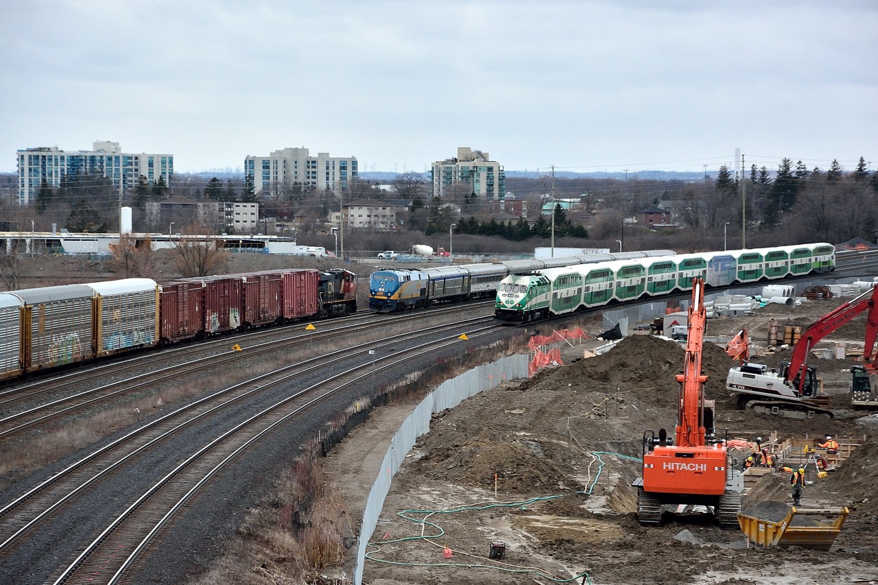Triples !
 
  
Some tardiness made this possible at the hardly ever a dull moment Hopkins Overpass.
 
  
From the left (south):
 
  
CN #371 with a single unit, the CN 2286  ( GE 2007 built ES 44 DC )  on the south service track is creeping down to the pot signal at Whitby....
 
  
VIA #64 with VIA #919 ( and always with photogenic equipment) is down eight minutes due to  connecting passengers off VIA #84
 
  
and the semi hourly GO west on the approach to Whitby 
 
  
( And just out of sight at the right is a tardy semi hourly GO east departing GO Whitby )
 
  
And the work goes on....for the new GO service facility
 
  
A Triples second first for this Photographer – and no errant empty tri-levels either ! (hey, hey).
 
  
March 18, 2016 image by S.Danko
 
  
More Triples
 
    
      February Triples  
 
   
sdfourty