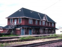 Here is a view looking S/W of the old all-purpose train station (aka: Old Drafty)in Hearst. The town was founded when the National Transcontinental pushed thru in 1913; subsequently the line became CN. Lot of space in this building on account the agent and others lived here, made a lot more sense than trying to commute from elsewhere in the bitter winters. MoW housed here. Express deliveries stored here. Town 'meeting place' at one time. The old building eventually outlived its' usefulness; when I visited here in 1985 the only "service" was a bus connection to Kap, and to the best of my knowledge this building is now long gone, replaced by that mini-sta on the right.
