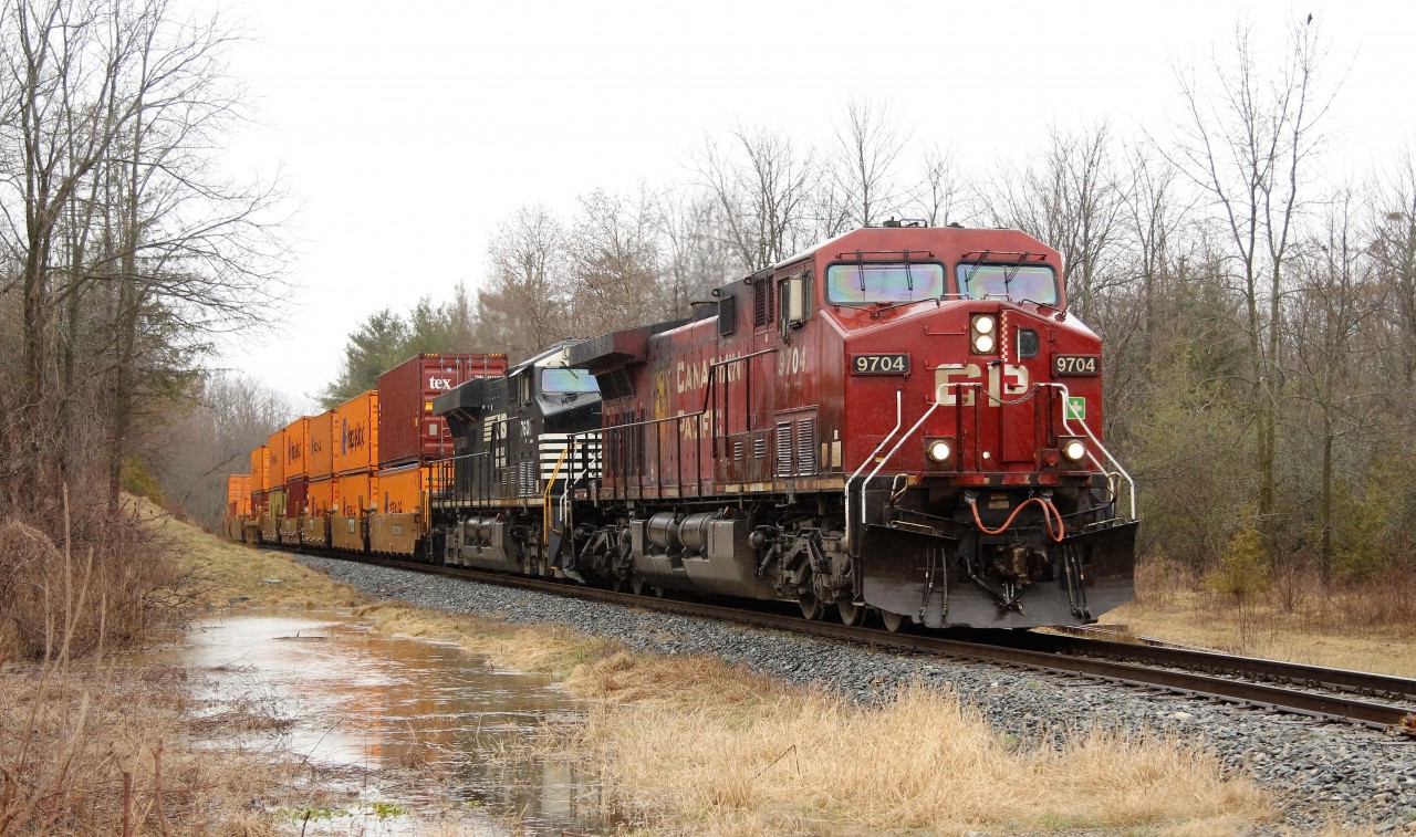 I, like most of you, don't like to take my shots in the rain, but once again I found myself out in it. This time I figured I would out smart mother nature and shot this from my truck through the window to keep my self and the equipment dry. So, along came this train, with its 288 axels and 5777 ft. length, heading south led by CP 9704 with NS 7601 aiding with the power on its way to Desjardins.