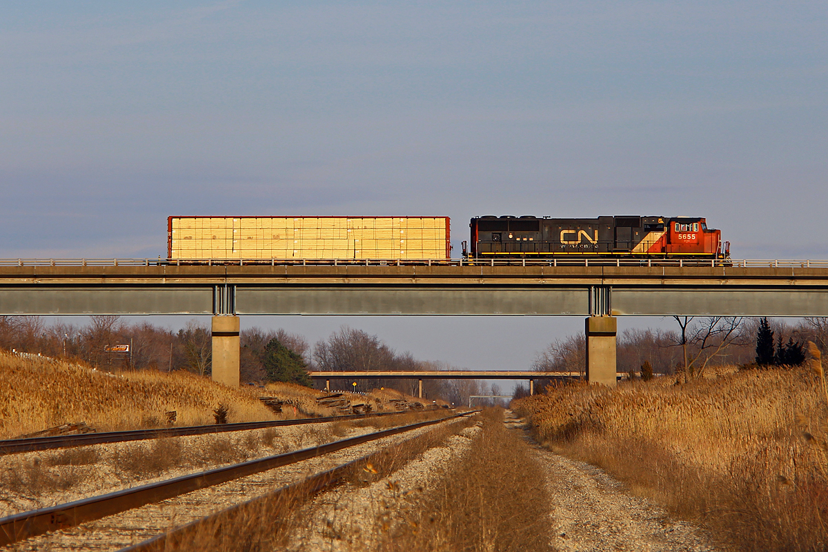I had wanted to get a shot here for a while. A CN on the Stamford Sub passing over the CP Hamilton Sub. Knowing CN 531 typically departs at 1600 from Port Robinson, I went to go see it there. As it left I took off towards Welland. However, I clearly forgot to factor in the many granny drivers in Niagara, so things didn't go as planned. I ended up being a dead head to head chase with 531, and then finally got ahead. However, when I rushed down to the CP ROW, I was welcomed with dead silence for several minutes. Southern Yard is just north of here, and it was clear to me he was working the yard, much to my relief. Nonetheless, I was a bit perplexed to see it cross with a single loaded centerbeam. I could guess where this single centerbeam was going, but I won't. I decided to chase after it, which was a mistake, as CP 255 was coming. I was not aware of this until I saw CN 531 meeting it at Robbins, and at that point it was too late, as I was hit by constant red lights on the way back. Sometimes luck gets countered by a lack of it.


The signal bridge in the distance is the former Brookfield controlled interlocking, where the CP Hamilton Sub once went to Niagara Falls. All there is now is an advance signal for CP to merge onto the CN Stamford Sub at Robbins, and a connecting track onto the former Hamilton Sub to Niagara Falls, which is now the Montrose Sub.