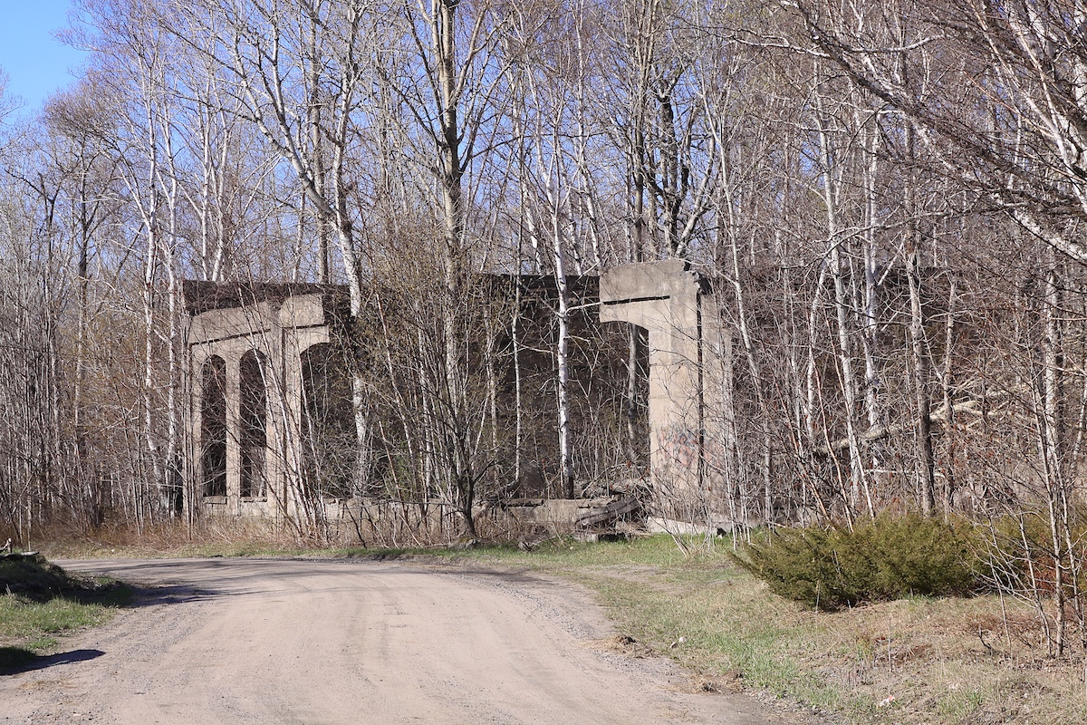 Depot Harbour, one of Ontario's largest ghost towns, was originally founded in the 1890s by lumber baron John Rudolphus Booth as the western terminus of his Ottawa, Arnprior and Parry Sound Railway (OA&PS).  At its peak the town had 1,600 permanent residents, along with a railway station and roundhouse, grain elevators, docks, hotels, stores and a church.  in 1904 Booth sold the railway to the Grand Trunk and it was subsequently inherited by CN in 1923.  After CN assumed control, they decided the roundhouse was not required in their network (with the facilities at South Parry so close nearby) and it was retired.  The 1930s were not kind to the old OA&PS - grain prices fell during the depression, a damaged bridge in Algonquin closed the western section of the line and the reconstruction of the Welland Canal reduced the importance of the town and railway.  By the end of the decade the town had fallen into disrepair and its population had plummeted.  

I found out about Depot Harbour in 2012 while reading Ron Brown's book "Ontario's Ghost Town Heritage" and learned that while the town had long since vanished, parts of the old roundhouse (made of concrete) still remained.  So the next time I visited the Parry Sound area I made a quick detour to Parry Island and took this picture.