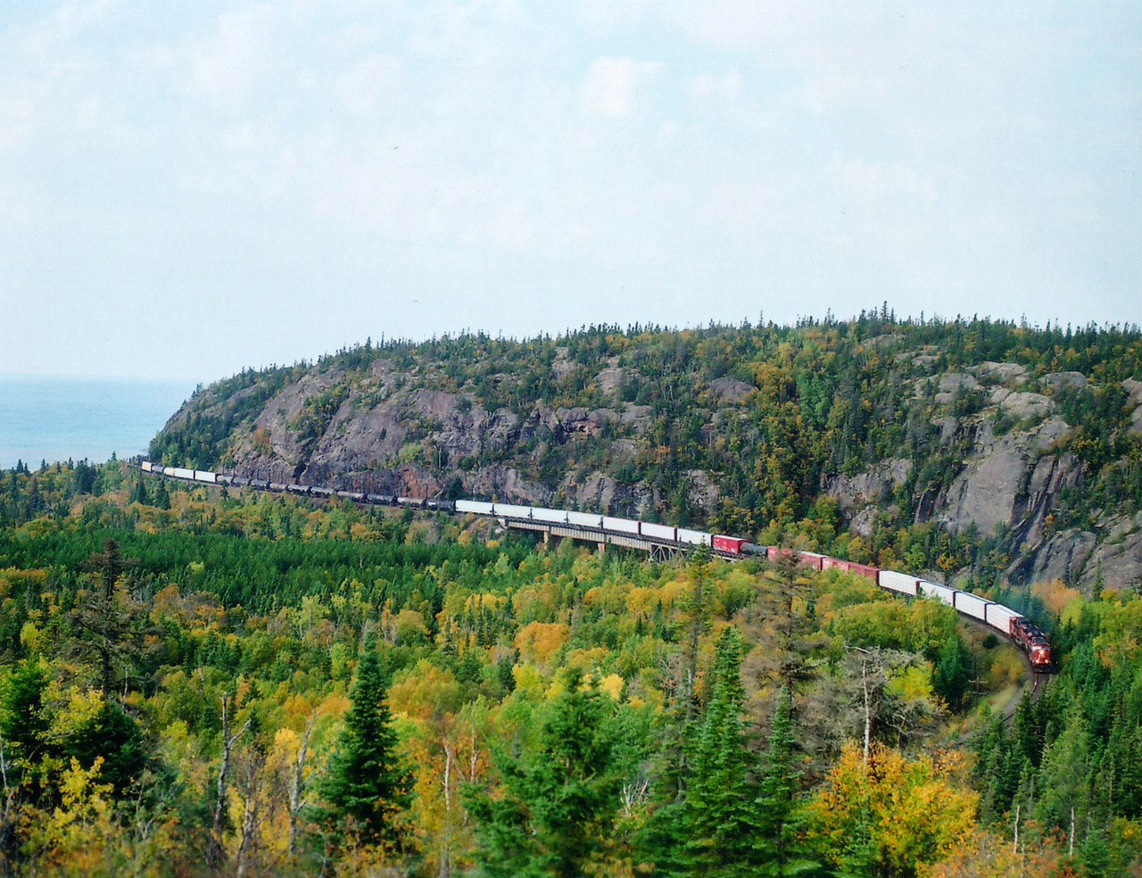 Just a hair to the west of the hamlet of Neys, and the Provincial Park of the same name, is this great photo location. Best in the morning as the sun climbs enough to eliminate foreground shadows, images like this can be had. Lake Superior is off to the left, and the SD90MACS CP 9135 and 9122 are rounding the bend eastbound over the Little Pic River bridge. I was hoping for a few nice angles here, but as luck (or lack of) would have it, on the way back from Thunder Bay we found CP experienced a derailment at Coldwell. So here I am, up around Superior, and all the trains have ground to a halt. Thems the breaks. :o(
For those interested, this image was captured on 400 ISO 120 film set at f5.6 and 500th sec using a Mamiya 645E.