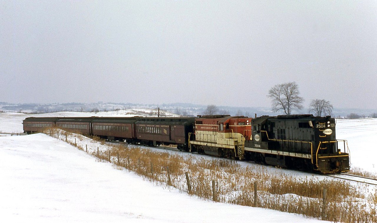 On January 14th 1967, the Upper Canada Railway Society ran a diesel fan trip on the Toronto Hamilton & Buffalo Railway operating Hamilton to Brantford, Waterford, and Welland. Power was TH&B parent New York Central's GP9 7504, and TH&B "Torpedo tube" GP9 402. Here the train is seen operating between Hamilton and Brantford, around the "summit" on the line.