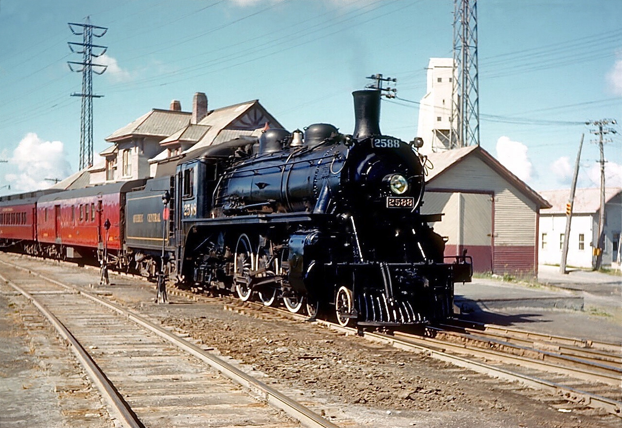 It's August 3rd, 1952 and Quebec Central Railway G-2 Pacific 2588 has just brought Train 1, which originated in Newport, Vermont, to a halt in Thetford Mines.  The train and its afternoon counterpart, Train 6, were the only Quebec Central trains to use Palais Station in Quebec City; other trains dropped their passengers off in Lévis from where they were ferried across the St. Lawrence.  Between Sherbrooke and Quebec a Café Parlor car was part of the consist of Trains 1 and 6.  And it is obvious from the locomotive's gleaming exterior that shop crews took pride in their work. G-2 class 4-6-2 Pacific 2588 was built by parent Canadian Pacific in 1912, transferred to the Quebec Central in 1930, and was retired in 1959.