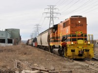 RLHH 3049 approaching Ottawa Street with 20 or so cars, as the conductor prepares to dismount to flag the crossing