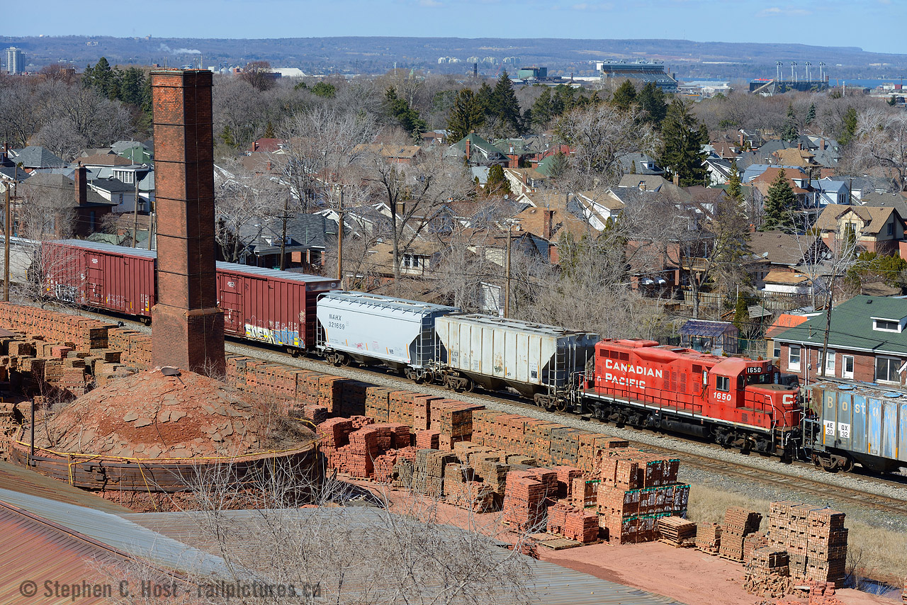 With a nod to  Ryan Gaynor who found the trails, here's my take on the Hamilton Century Brick angle. Unique because I had the chance to use a CP GP9 as my subject, two years after the last gp9 was taken off the roster - too bad 1650 wasn't a former TH&B unit.
The Century Brick factory is still a going concern one and a half centuries later, I chose to frame the smokestack, 'hive' and finished product into the shot rather than the entire facility.
Funny thing is the only reason I ever really ventured into this part of Hamilton as a teen was to visit Girlfriends. Now I visit because of trains... hmmmmmmmmmmmmmmmmmmmmmm.