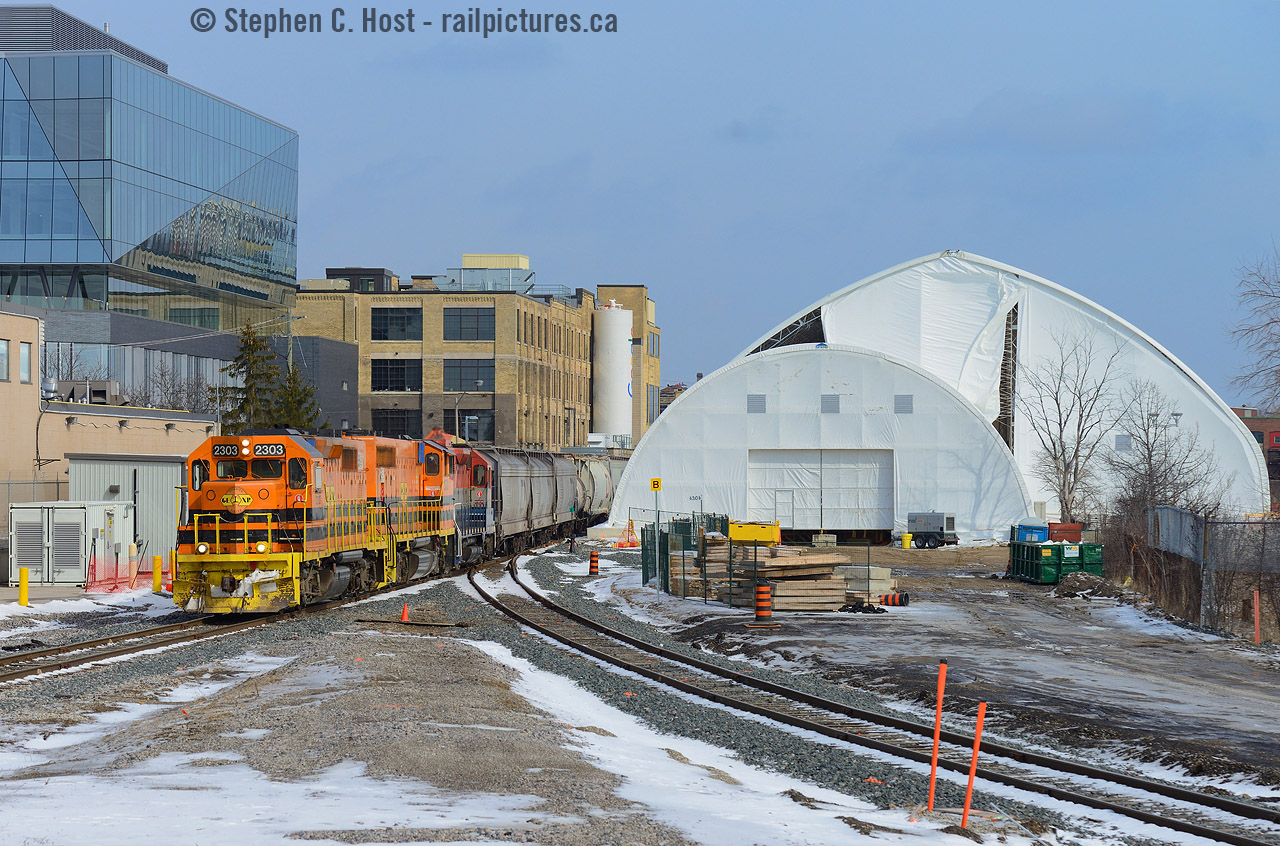 The great domes now dominate the Kitchener landscape as construction of the "ION" LRT infrastructure continues - this will be used to pour concrete this week for the King St underpass, and to keep the project on-time a $2M Dome was required to cover the site. This work should have been done earlier this year but Metrolinx purchase of the track plus other things delayed the underpass project adding to the local taxpayer ire (as reported in the papers). ION is expected to be in service in 2017.
At left of the dome is a new glass and yellow brick industrial building retrofit - for the new Google Canadian headquarters - you can kind of see the familiar Google logo colours on the white silo. The track at right is the Huron Park Spur which has been re-aligned.