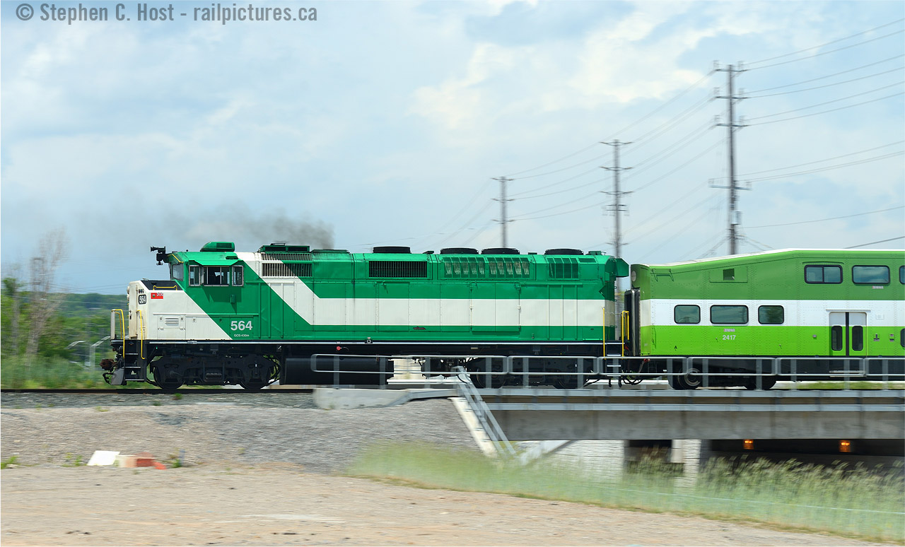 Juxtaposition If you saw this photo 6 years ago you'd probably go WTF. You may still go WTF, but for different reasons. Where's the GO logo? What's that new scheme on the coach? Is this a new commuter operation? Welcome to the new GO Transit! Only time will tell if the F59's get the 'new scheme' some day, for now this is the closest you can get to a juxtaposition of the new and old..
Since this photo was taken. a nice fence has gone up along King Rd. Kiss yet another photo spot good bye.