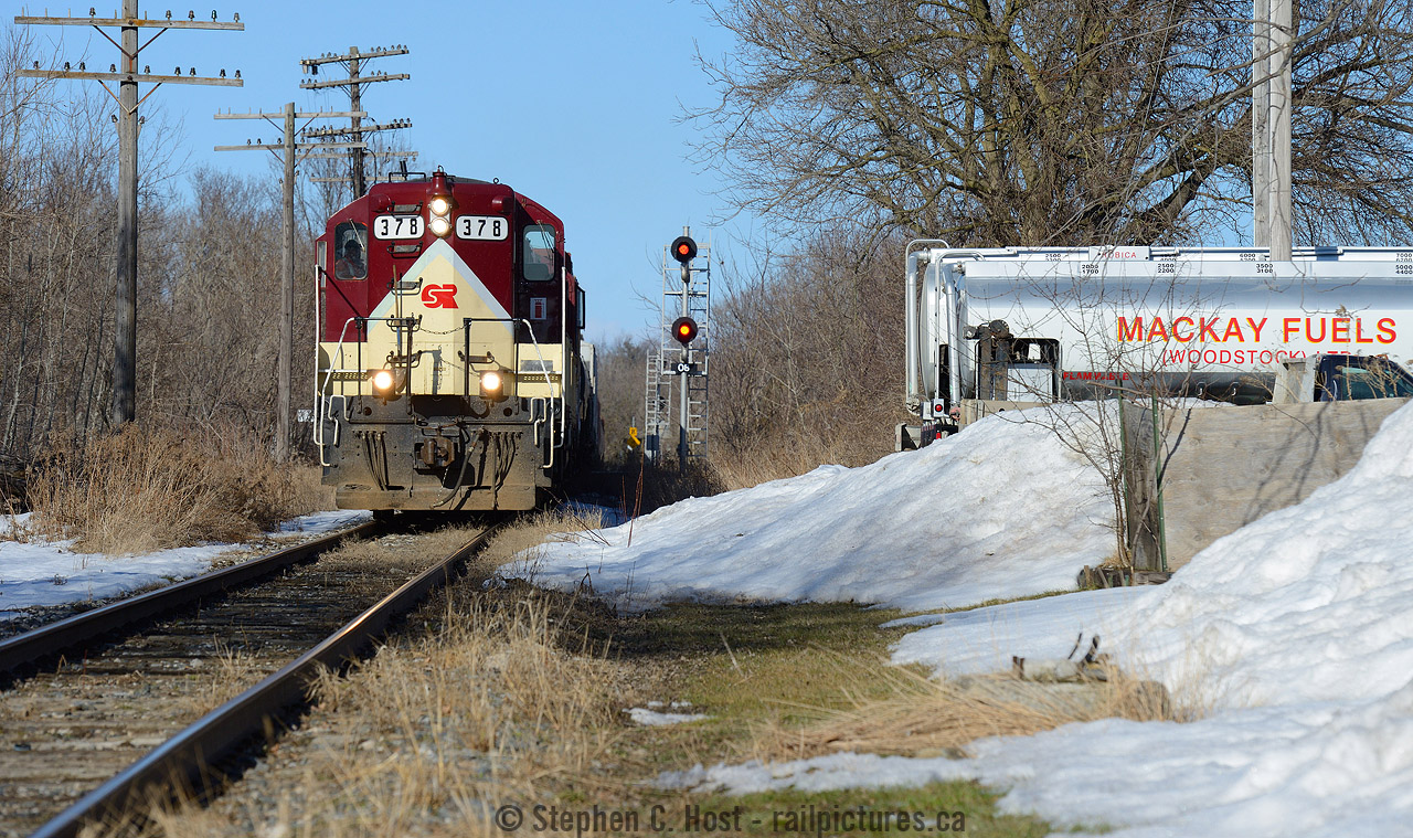 Only on the OSR - freshly painted high-nose GP7 is passing a small fuel supplier in Woodstock Ontario, also the location of the CNR/CPR diamond with the usual wayside implements for a railway crossing at grade. You can't get tired of the OSR.... really you can't. If you haven't been yet, time to plan your trip.