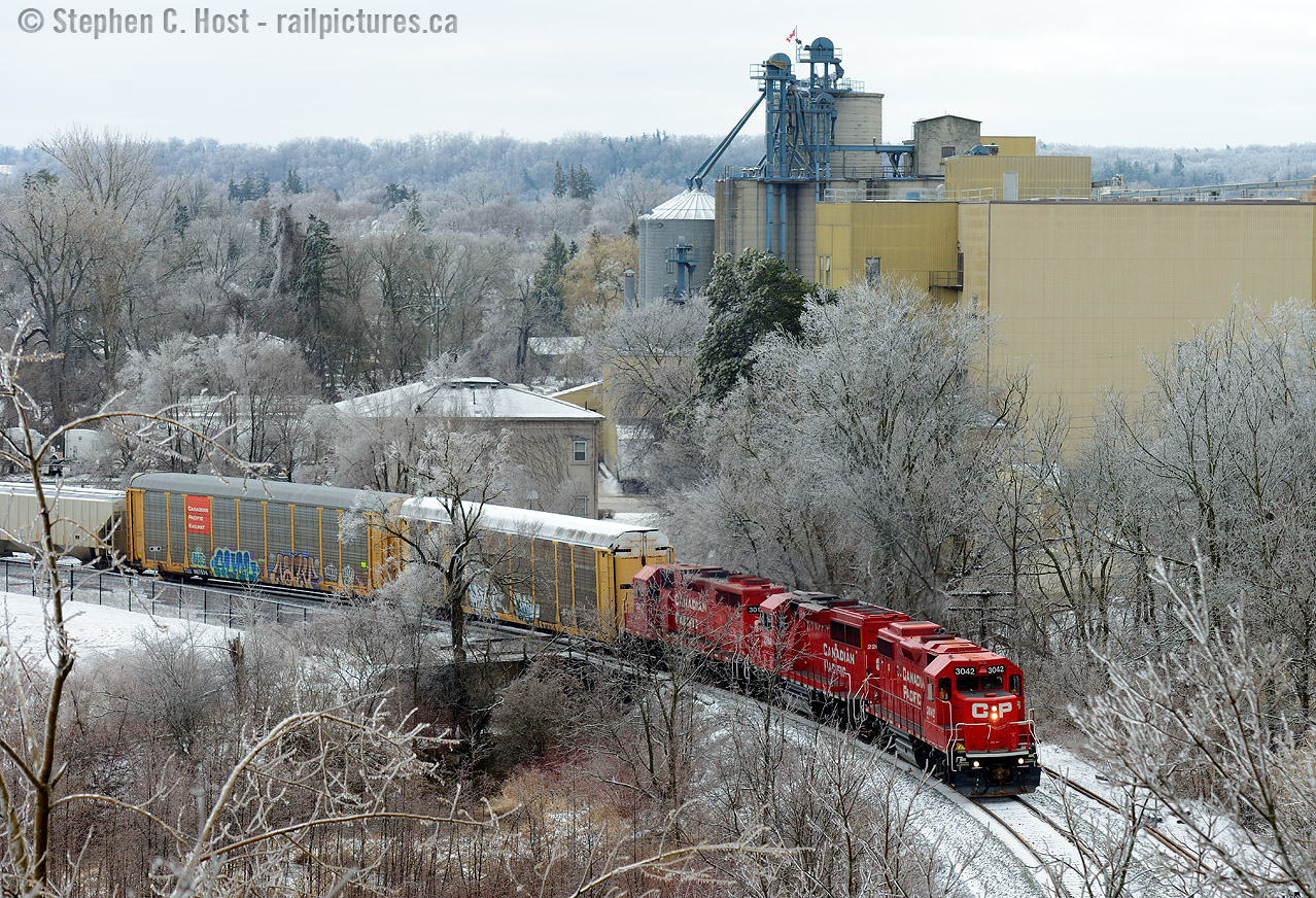 Everything is covered in ice, the trees are white, the Dover flour mill (Now owned by P&H) continues to churn out product, and to the left is the former Grand River Railway head office building, now preserved and used by an advertising agency. T72 has 51 cars in tow and the motive power growls as they have accelerated into high notch for the 2.5% grade. It was  9 years ago I last did this shot..  and one can see it's growing in and getting difficult!