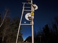 The headlights of a westbound  light up the RoW as this old US&S signal display a clear signal for the train crew on this somewhat mild evening.