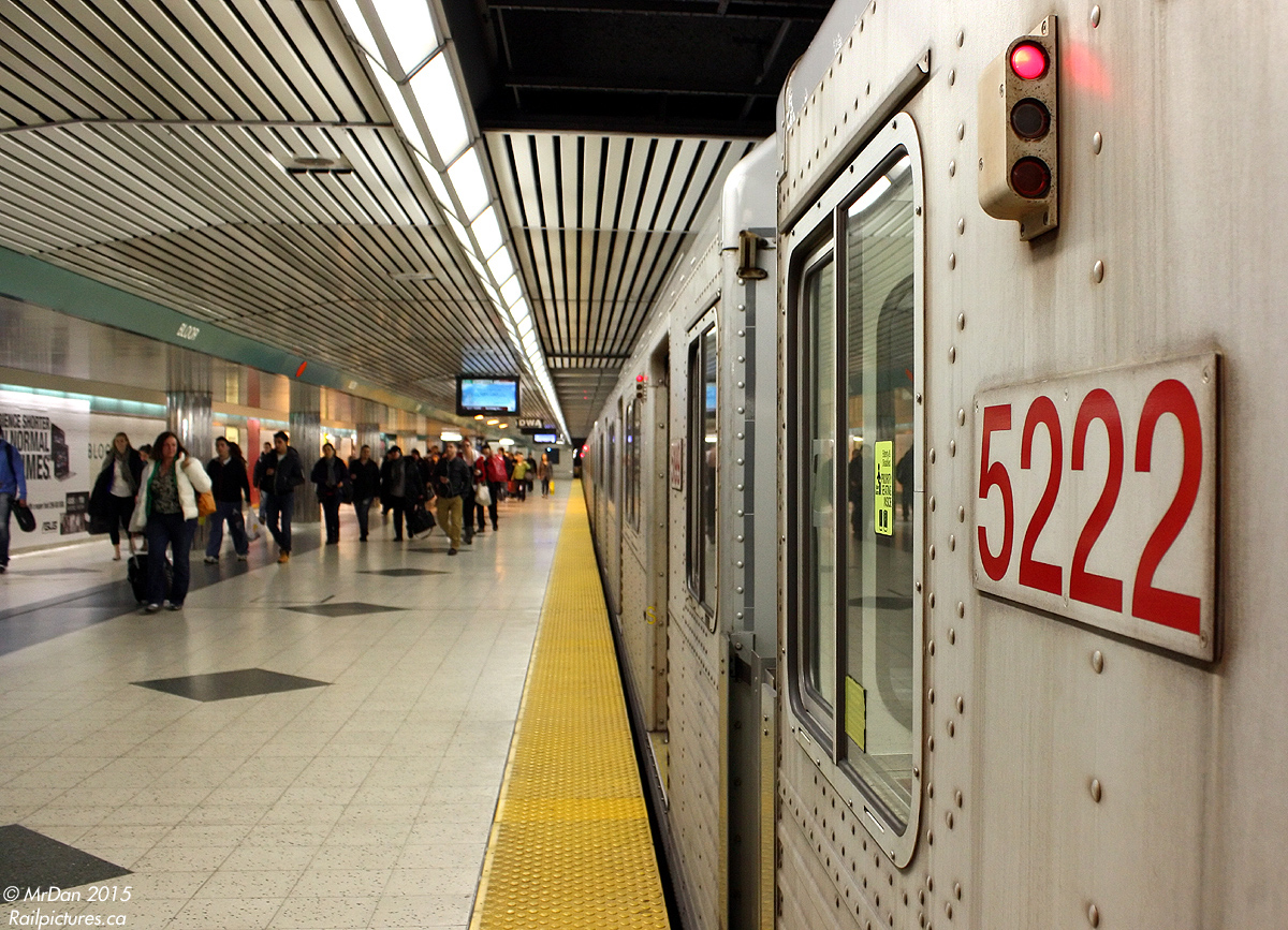 The hustle and bustle of Toronto's busiest transfer station on the subway system: Bloor-Yonge. A northbound train of T1's with TTC 5222 in consist pauses to load passengers on the Bloor station platform (of the Yonge line), as others that have gotten off walk north to the escalators down to the Yonge station platforms beneath (Bloor-Danforth line), or the exits to the street above.