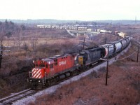 A long time back, (image 12431) I posted the first Detour Train that I witnessed courtesy of the infamous Mississauga Wreck of Nov. 1979. This incident was caused by a night-time derailment in Mississauga of CP train #54, a burned off wheel mid-train caused a pile-up and explosion that resulted in the evacuation of more than 200,000 people. A few following trains caught in the resulting closure of the line detoured down from Guelph Jct into Hamilton and then eastward to Toronto. This was the second train I caught, and it is rather late in the afternoon already. CP 4242 and C&O 3539 snake down over the Hwy 403 bridge with what is a rather amazing number of autos and truck cabs on the old style wide open carriers. Prone to vandals! By this time of the day word has gotten out and rather than just the one lone fan on the hillside overlooking the highway, we see 4 or 5 in this image.