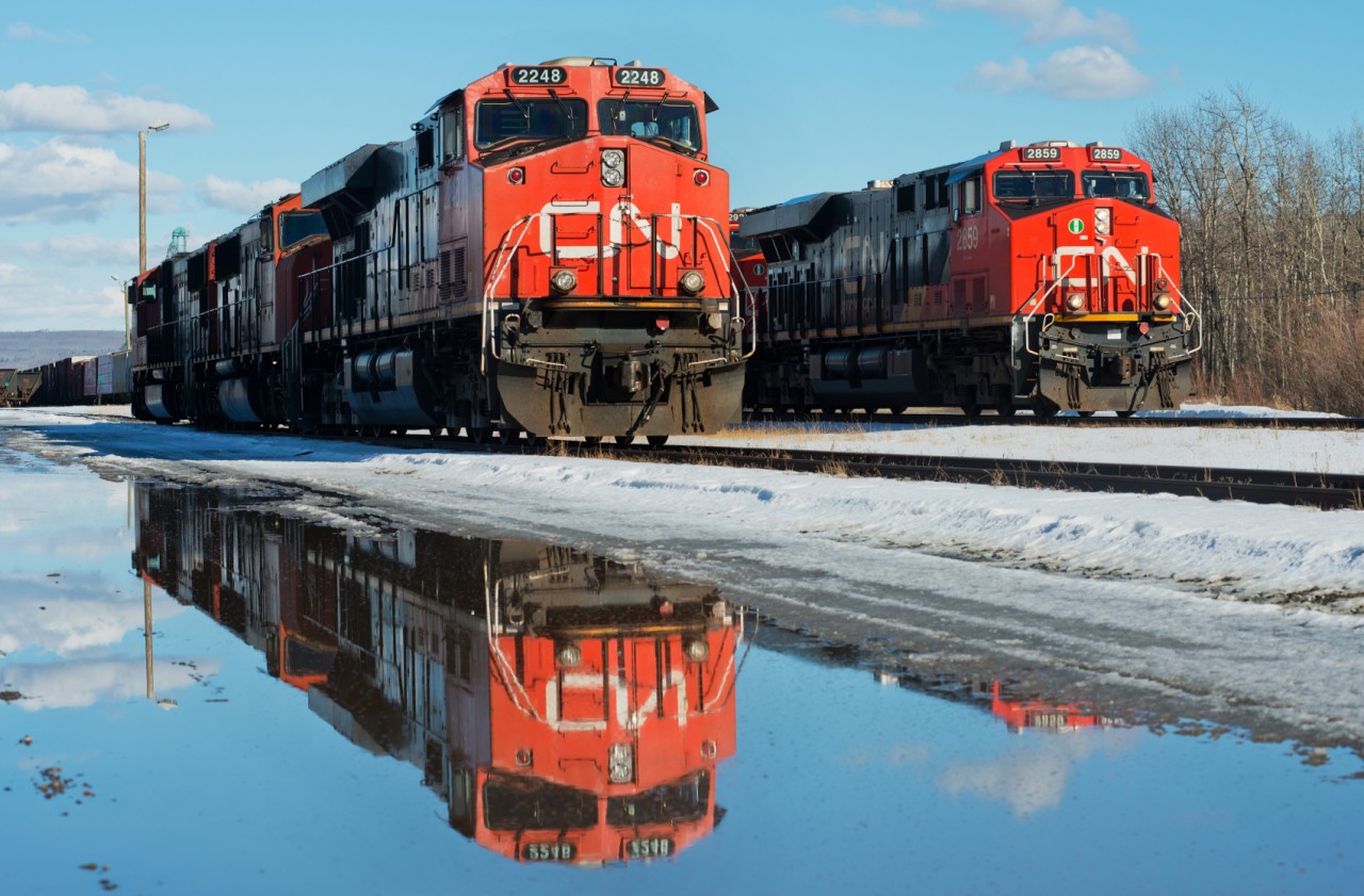 Power for train 575 to Fort St John creates a nice reflection in a nearby puddle. In the background train 472 to Prince George goes about building it's train. Despite both being "Gevo's", there are many spotting differences between the 2248 and the 2859.