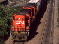 A local train is returning from Dartmouth? toward Rockingham yard. The 1700's were the most common (almost to exclusivity) locomotive seen on locals in Nova Scotia. The pile of gravel in the background is from the quarry that lies to the right of the tracks. It is still an ongoing business, where they blast the granitic bedrock and run the loosened material through crushers. I don't know what the track going off to the left served at this time, though.