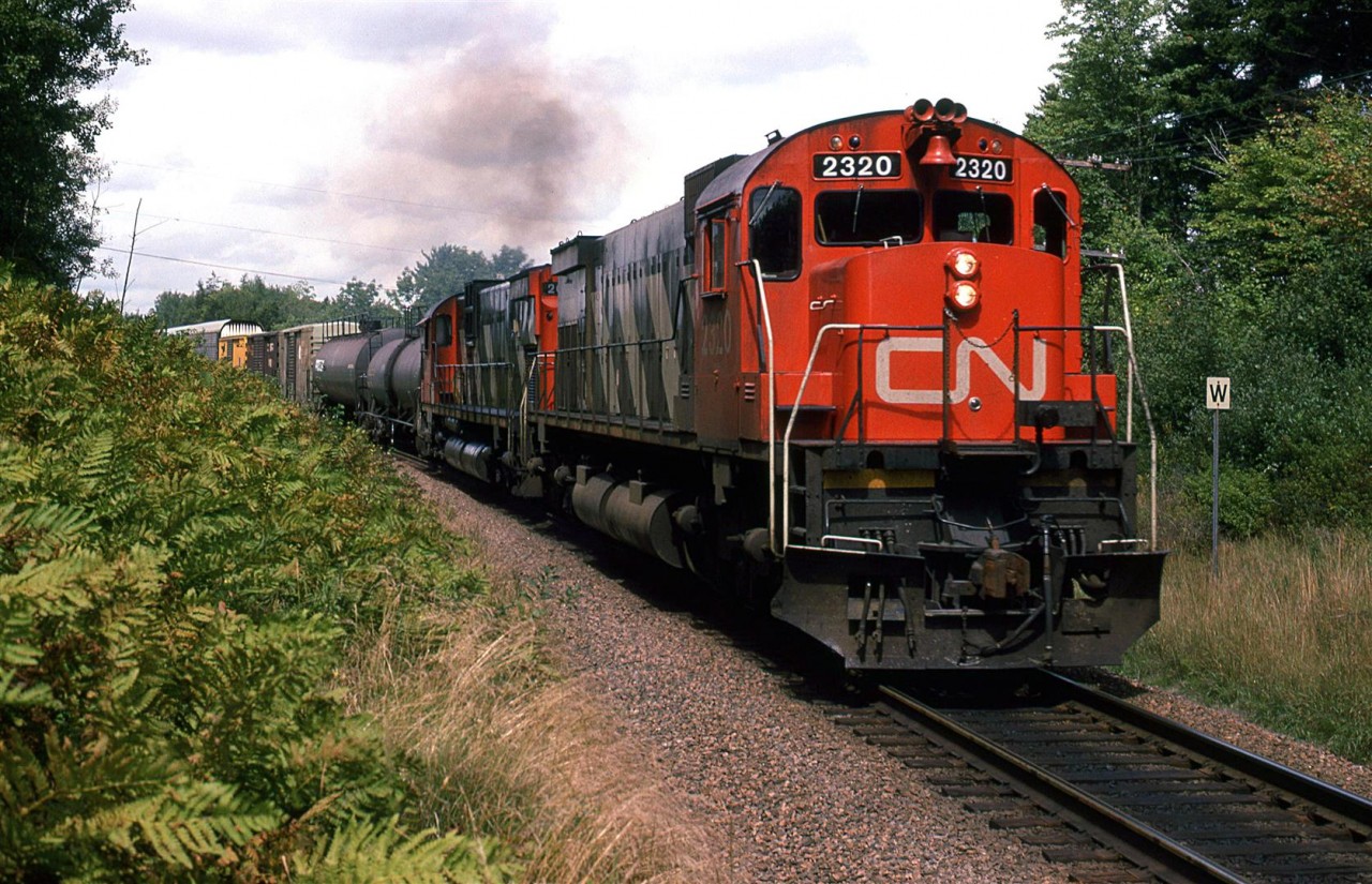 An eastbound manifest train with two M636's leading chugs through Windsor Junction. On my previous visits to Halifax, it seemed as though all the freight trains operated at night. My '86 though, operations changed  and a few freight trains could be seen. Without a radio, however, it was really tough to catch one.