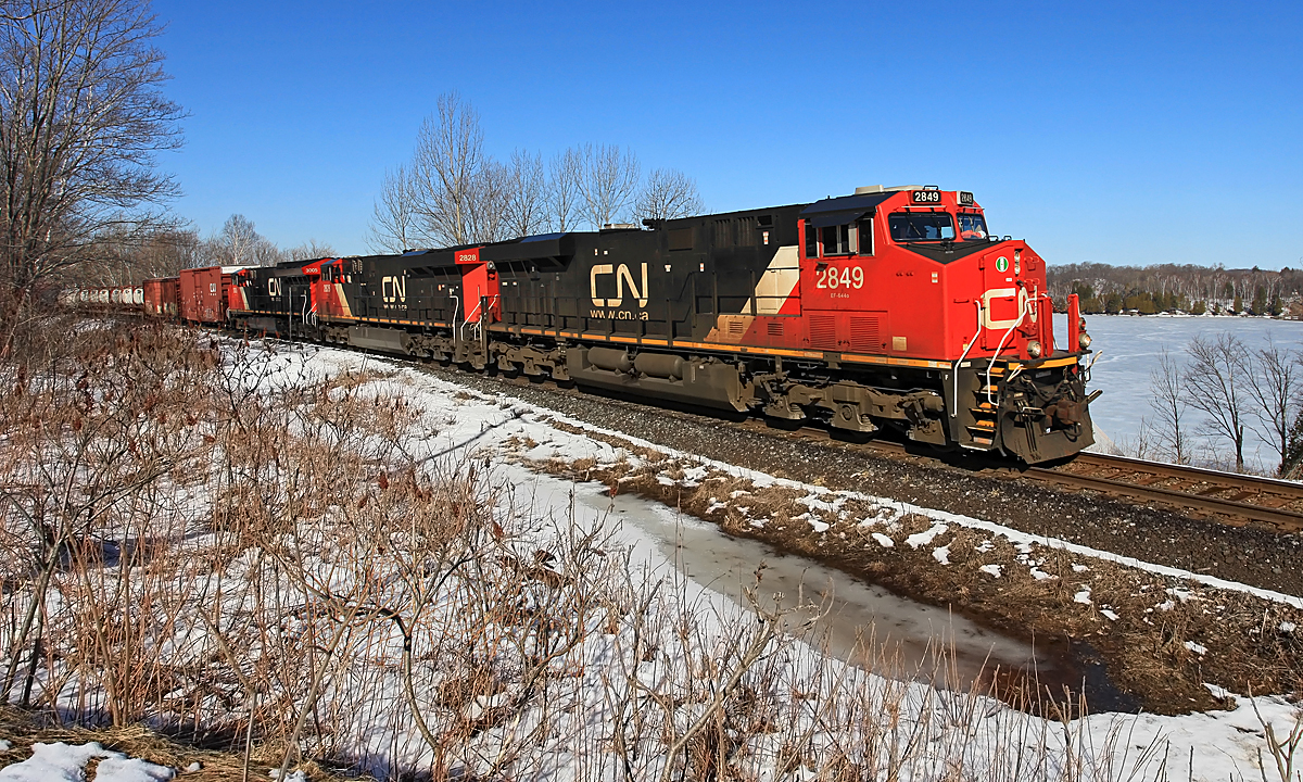 A normally nocturnal CN 451 - running late enough to put it well into daylight - skirts the south shore of Lake Vernon with work just ahead in Huntsville before continuing on to North Bay.