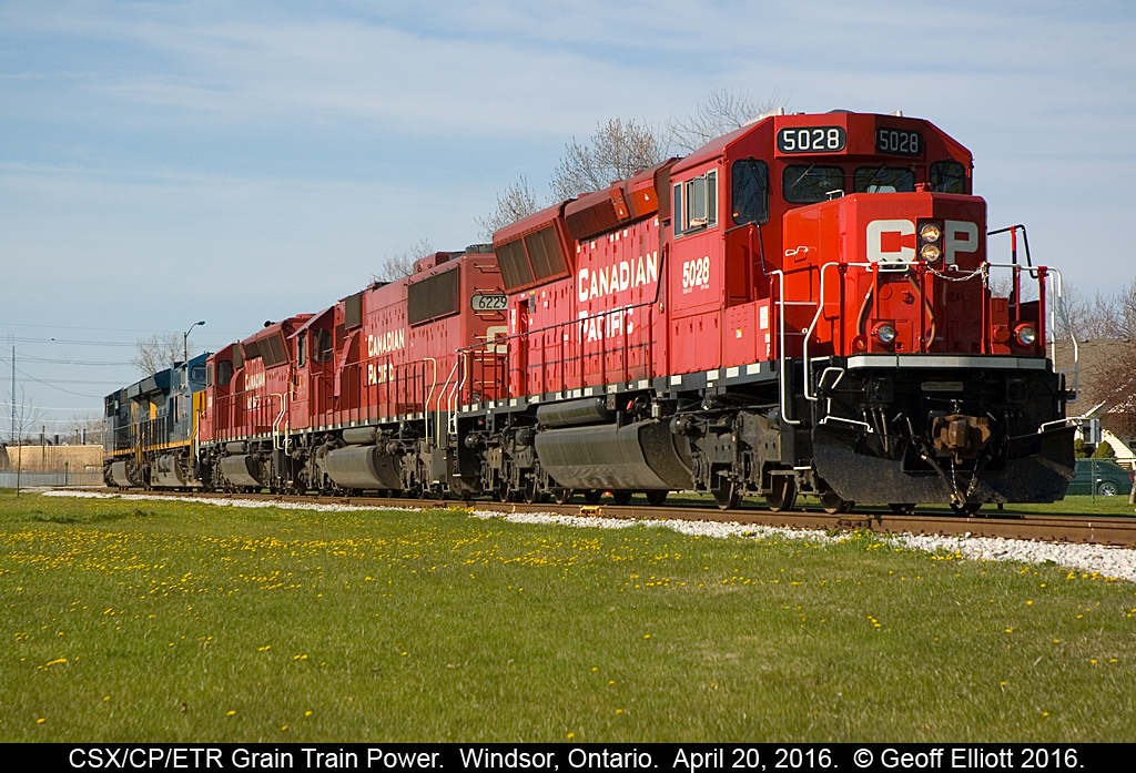 After ETR GP9 #108 had left for Ojibway with the 80 car empty grain train CP T28 power had to wait at Howard Ave for a green signal to head back to the CP main.  Having just received the 'high green' (seen way in the distance) 5028 throttles up to head back west to home rails.  From there the power will return to CP's Windsor Yard where the CSX power will remain until the grain train returns from ADM loaded and ready to head Stateside.