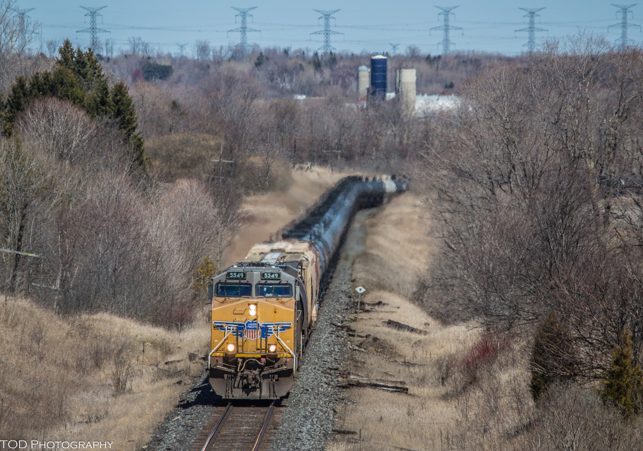 A single UP GEVO leads a snake of empty ethanol tanks up the hill through Newtonville.

UP 5549