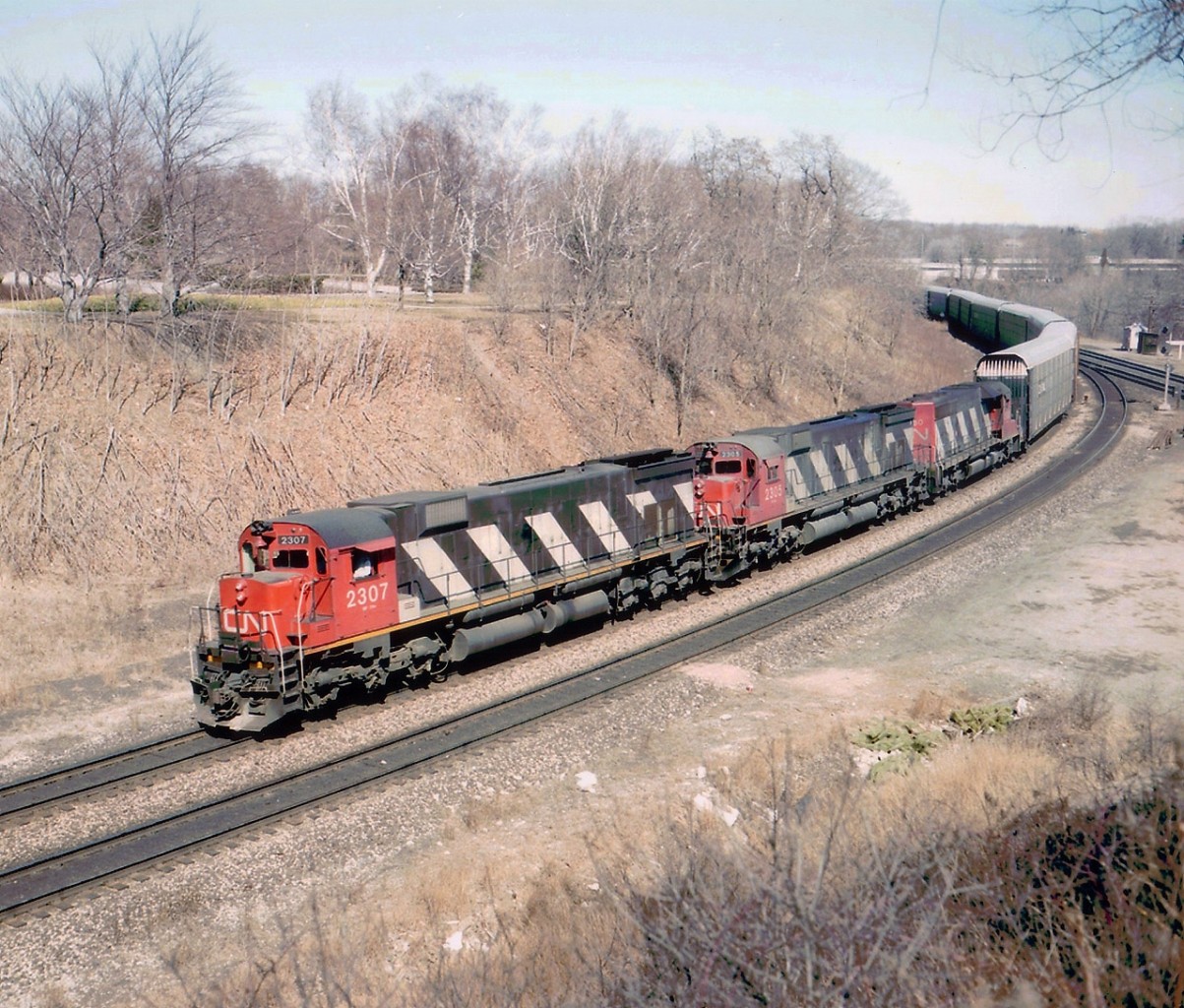 A day at Bayview as it used to be: No fences, no hassles, and this particular day, no fans, either. Except this one. And the reward was this westbound with a pair of M-636s up front, CN 2307 and 2305, both off the roster for 20 years now. Trailing is a puny SD-40 # 5080, and since they are all off the CN roster as well, I guess we can tolerate it. I went ahead of this train as far as Copetown. To hear them struggle on the grade was a real treat.
