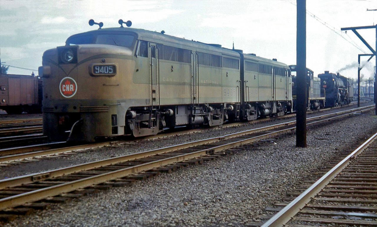Canadian National steam and first generation diesels mingle in Montreal: MLW FA1's 9405 and 9404 (in the early green and gold scheme) sit ahead of a SW1200 and 4-8-4 Northern, at CN's Turcot shop/yard facilities in 1954.  As CN dieselized, it moved its operations from the flat-switched steam-era Turcot yards and shops to the newer Montreal hump yard. In 1960-61, Turcot became the gathering ground for dozens of retired steam locomotives, stored and scrapped on site by Point Ste. Charles shop employees.