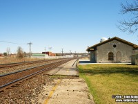 Napanee is another fine example of the architecture used when the Grand Trunk built it's many stone stations on the Toronto - Montreal mainline. I took a wide angled shot to show the surroundings, as it has changed in the many years from my first visit to the grounds as a youngster. 
<br>
Just to my left, is what used to be the Canadian Northern mainline that went to Smiths Falls. This line remained until the late 80's early 90's, where it was trimmed down to become a spur leading only to the Goodyear plant. Eventually, Goodyear closed and recently the spur removed. I was also saddened to come here on this trip and find all the fencing that had been installed recently...but then was reminded of a "Letter to the Editor" article I had written to both local papers almost 20 years ago. In that article, I had called out that fencing should be put up, after my own encounter with the Ontario Provincial Police.
<br>
Some of the original platform remains at each end of the station, which i can recount standing on in one of my many trips to this location. You can see how much the line has been built up, and I should also be happy  that the station remains too. Sometimes all you have is memories...and if I had stayed for only another 10 minutes I would have captured a westbound VIA on the curve speeding towards Belleville. 
