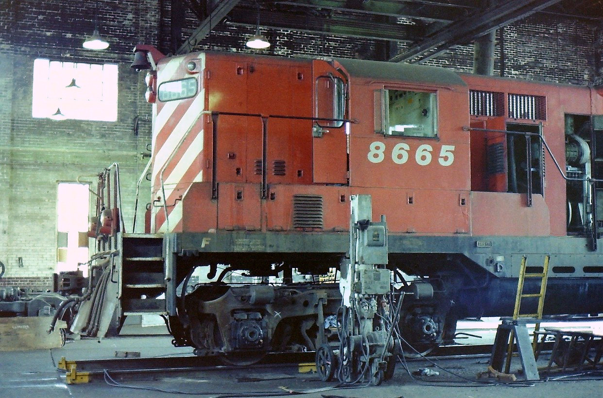 Knowing that the CP operations at the Drake St. yards were coming to an end my friend (Jack Lord) & I drove down to the yards on a nice sunny day. I remember that it was a Sunday & no work was taking place. We took as many photographs as we could till we ran out of film. In this case we spotted CP 8665 jacked up in the newer portion of the roundhouse, so being careful not to touch anything we took a couple of shots showing the locomotive as it sat there. The sad thing is that there was so much more to photograph & we missed it.