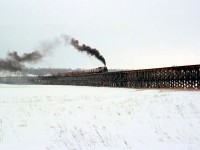 Canadian Pacific Royal Hudson 2857, operating on a fantrip from Toronto to Port McNicoll and back, hauls its 7 car consist across the Hog Bay trestle during a photo runby. It was a somewhat dreary March day, but the runby here was a good idea as the Bay was still frozen so one could safely get some photos. Also included on this day was a visit to the Port McNicoll roundhouse for photos of the still active 2-8-0's assigned there, the last regularly assigned steam engines on the CPR. The later (and last) trip in June had better weather for photography but not to photo the trestle (I could not attend that trip).<br><br>Built in 1908 to span Hog Bay off Georgian Bay, this 2142' long, 40' high wooden trestle allowed the CPR to reach Port McNicoll, where elevators at the port for grain handling, and CPR's fleet of lakeboats produced traffic (summer "Boat Trains" were run up the MacTier to the port until the late 50's). CPR abandoned much of their Port McNicoll Sub including this trestle in 1971, in favour of accessing Port McNicoll over CN's Midland Sub via trackage rights (which crossed underneath the trestle at the south end). It was eventually demolished in 1978.<br><br><i>Other photos from the same day:</i><br>2857 at Union Station: <a href=http://www.railpictures.ca/?attachment_id=23269><b>http://www.railpictures.ca/?attachment_id=23269</b></a><br>3632 at Port McNicoll: <a href=http://www.railpictures.ca/?attachment_id=21826><b>http://www.railpictures.ca/?attachment_id=21826</b></a><br>3722 at Port McNicoll: <a href=http://www.railpictures.ca/?attachment_id=22492><b>http://www.railpictures.ca/?attachment_id=22492</b></a>.