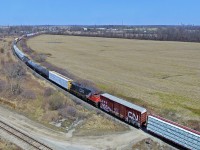 DPU technology has invaded most parts of the CN system, however, Niagara has largely been exempt from that. Great for balancing weight in trains, they are also great for lengthening consists, and killing off trains. Whether this will be the solution to CN 330 and 331's demise will be answered in the coming weeks. A couple nasty hills around St. Catharines (the infamous Jordan and Glenridge dip) and Niagara Falls have claimed dozens of knuckles over the years, and have made running large trains quite difficult. Nonetheless, this 421 was massive, and very heavy. The trip from St. Catharines took well over an hour, where as 330 was able to travel this distance in 40 minutes usually, indicating 421 was probably down to a crawl while climbing the grade into Niagara Falls. 2524 serves as the DPU as 421 rounds the curve at Po rt Robinson West. The track in the foreground is the CN Thorold Spur, and the skyline on the high right is Niagara Falls. 