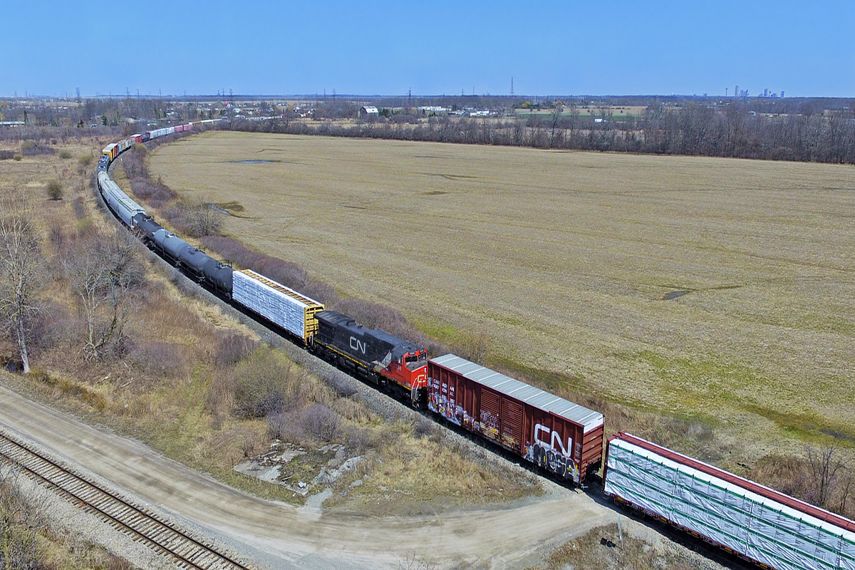 DPU technology has invaded most parts of the CN system, however, Niagara has largely been exempt from that. Great for balancing weight in trains, they are also great for lengthening consists, and killing off trains. Whether this will be the solution to CN 330 and 331's demise will be answered in the coming weeks. A couple nasty hills around St. Catharines (the infamous Jordan and Glenridge dip) and Niagara Falls have claimed dozens of knuckles over the years, and have made running large trains quite difficult. Nonetheless, this 421 was massive, and very heavy. The trip from St. Catharines took well over an hour, where as 330 was able to travel this distance in 40 minutes usually, indicating 421 was probably down to a crawl while climbing the grade into Niagara Falls. 2524 serves as the DPU as 421 rounds the curve at Po rt Robinson West. The track in the foreground is the CN Thorold Spur, and the skyline on the high right is Niagara Falls.