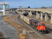 <b>A potash train past the remnants of the CN Lachine Spur.</b> CN B730 with 152 loads of Potash destined for Saint John, NB is slowly starting to leave Turcot West in Montreal after changing crews. Power is a trio of ES44AC's, with CN 2934 & CN 2812 at the head end and CN 2940 bringing up the rear. At left is the now abandoned Lachine Spur, with a large pile of dirt covering part of the old right of way.