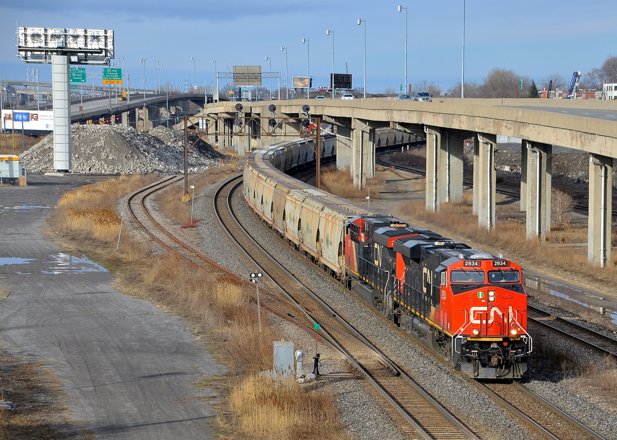 A potash train past the remnants of the CN Lachine Spur. CN B730 with 152 loads of Potash destined for Saint John, NB is slowly starting to leave Turcot West in Montreal after changing crews. Power is a trio of ES44AC's, with CN 2934 & CN 2812 at the head end and CN 2940 bringing up the rear. At left is the now abandoned Lachine Spur, with a large pile of dirt covering part of the old right of way.