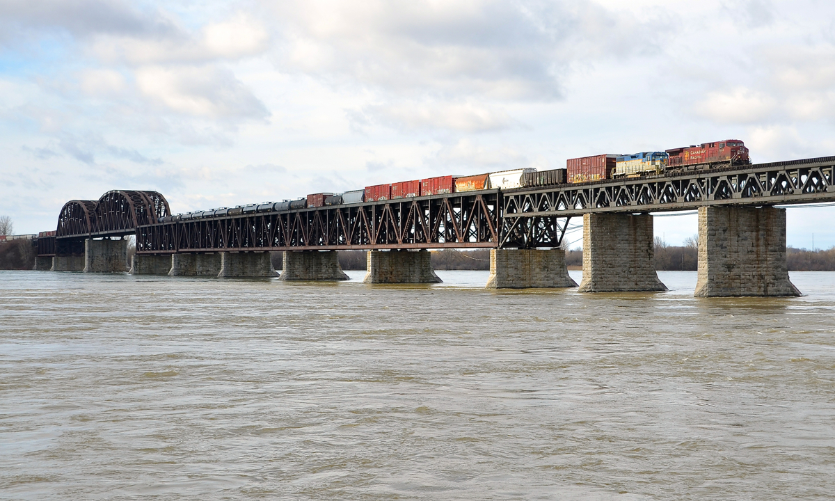 Bringing in a D&H unit for servicing. DH 7304, One of two remaining units on the CP system still sporting the D&H lightning stripe paint scheme, is trailing on CP 253, with CP 8603 leading as the train crosses the St-Lawrence River. DH 7304 is en route to St-Luc Yard for routine servicing.