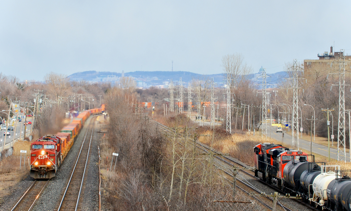 CP westbound, CN eastbound. As I start shooting CP 143 on CP's Vaudreuil sub at left, a slightly earlier than usual CN 376 pops into the frame at right on CN's parallel Kingston sub. Both trains are powered by GE products - CP 143 is westbound with ES44AC's CP 8851 & CP 8727, while CN 376 is eastbound with ET44AC 3008 and ES44AC CN 2874.