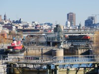 <b>Leaving the Port of Montreal.</b> CN 2568 is leading CN 149 as it leaves the Port of Montreal. Visible in this photo are locks for the Lachine canal, a preserved tugboat, the stack of a laker laying over, the Olympic Stadium and Radio-Canada headquarters, among other things.