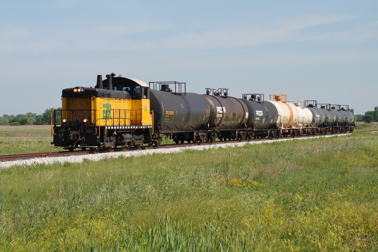 The Essex Terminal is a railway that hasn't had had vast amounts of coverage on this site, so I thought I'd add to the catalogue. Seen here is ETR 105 pulling 9 tank cars south towards Amherstburg, roughly 15 km south of Windsor. Their destination is about 5 km south of here along Thomas Road, where they will shove their train into the former General Chemical property to reach Honeywell, who manufactured hydrofluoric acid. The crew will drop the last 6 cars at Honeywell then take the first 3 tankers-full of Crown Royal Whiskey from Gimli Manitoba-to Diageo at the southern most point of the railway.

Today Honeywell is closed, shuttering operations in 2013, and this local has been reduced from a daily run to 1-3 trips per week. The ETR has lost a ton of freight over the past 10 years, losing 4 of their largest customers since 2006. There were 5 customers in Amherstburg 10 years ago, now only 1 remains.