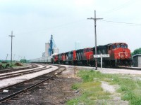 Back when CN was still in control of the Hagersville subdivision this southbound rolled into town on a very hot June afternoon. CN 9637, 9460, 9501, 3530 and 7048 made up the power; and a long string of new hoppers followed. Way back at the 'tree line' on the left one can barely make out a semaphore....one of the last I have seen in Southern Ontario. I followed this train from Caledonia, and was relieved when it stopped, as then I could plead with them to close the front door. Very distracting, no?  Power consist on this train now all off the roster.....9637 became Railpower RP20BD 5401, 9460 went to Western Rail in 2007; 9501, retired 2001; 3530 to Hudson Bay Rwy, and 7048 retired 2007. As well, the track is now leased to the Southern Ontario Rwy.