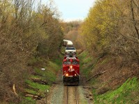 The cool spring morning silence was interrupted as CP 247 powered its way up the grade, led by CP 8911 with CP 8895 for assistance, hauling a near 8300 ft. load up to MM 64 and under the Snake Road overpass in the town of Waterdown.