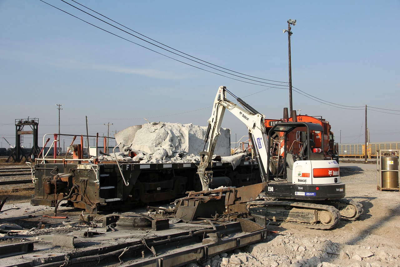 Hump control cab 1150 awaits its fate behind two former SW 800 and 1200 switchers.One upside down in the fore ground  Now you can see clearly whats inside a yard slug. The former SW 800 did not go down without a fight though. The massive excavator with a jack hammer attachment could not break apart the large concrete ballast block. The tiny jack hammer unfortunately was steady and precise.